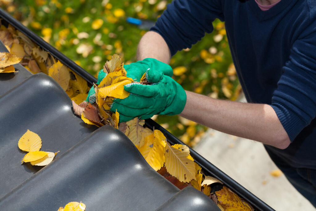 Man cleaning rain gutters